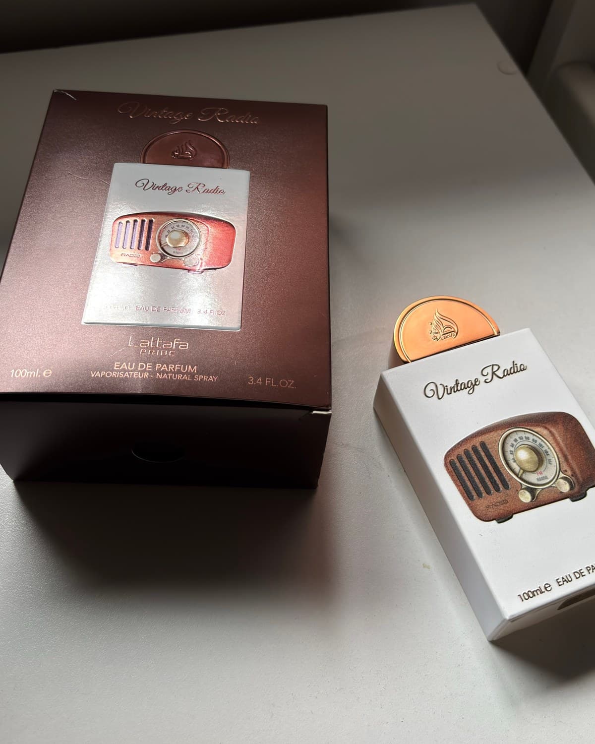 Lattafa Vintage Radio, frasco de 100 ml, sobre la mesa