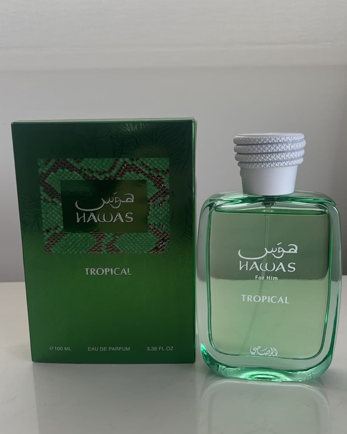 Rasasi Hawas Tropical, frasco de 100 ml, sobre la mesa